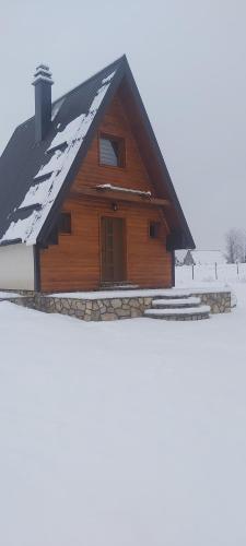 a wooden house with snow on the roof at Guest House Zabljak in Žabljak