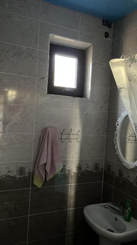 a small bathroom with a sink and a window at Дастан гостевой дом in Naryn