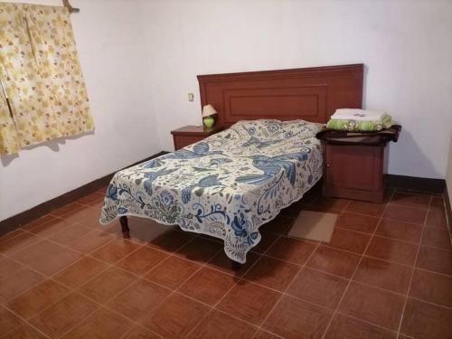 1 dormitorio con 1 cama con manta azul y blanca en Tu Casa en Miahuatlán: Ideal Familias y Grupos en Labor