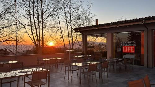 a restaurant with tables and chairs with the sunset in the background at Hotel Relais VillaGrancassa in San Donato Val di Comino