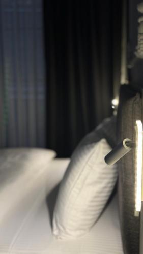 a close up of a pillow with a pen on a bed at El Baboos Hotel in Bostaniçi