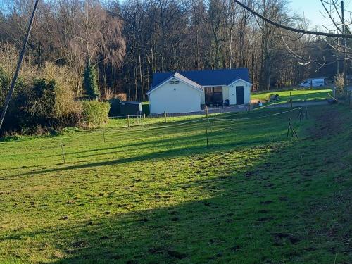a house in the middle of a grassy field at The Bungalow, Forest of Dean in Coleford