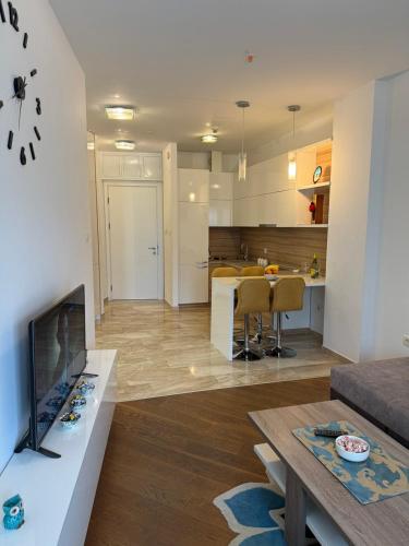 a kitchen and living room with a table and a couch at Apartman Anna Tre Canne Budva in Budva