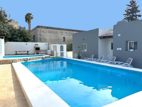 - une piscine d'eau bleue dans une maison dans l'établissement Villa Sunny Side, à Mellieħa