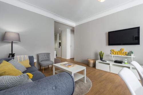 un salon avec un canapé bleu et une télévision dans l'établissement Ultra Central Large 2 Bdr near Massena Square, à Nice
