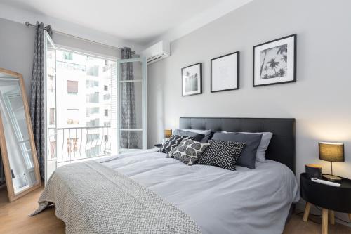une chambre avec un grand lit et une grande fenêtre dans l'établissement Ultra Central Large 2 Bdr near Massena Square, à Nice