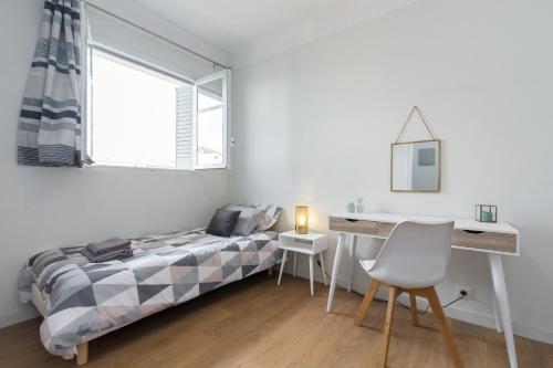 une chambre avec un lit, un bureau et une fenêtre dans l'établissement Ultra Central Large 2 Bdr near Massena Square, à Nice