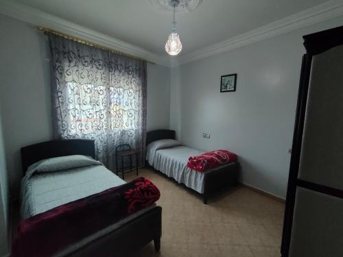 una camera da letto con due letti e una finestra di La Luna Rentals a Asilah