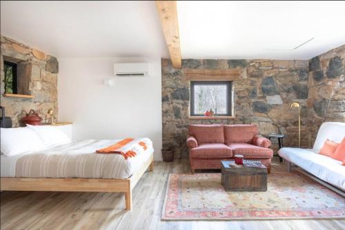 - une chambre avec un lit et un mur en pierre dans l'établissement Studio Guest Suite in Forest Cottage, à Tryon