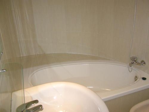 a white bath tub in a bathroom with a sink at APARTAMENTO TRIANA in Seville