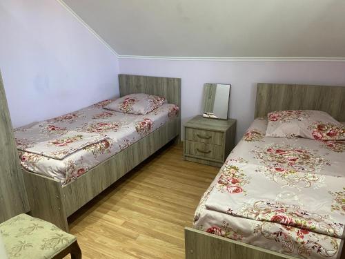 a bedroom with two beds and a table and a mirror at Homestay in Batumi Дом в Чакви in Chakvi