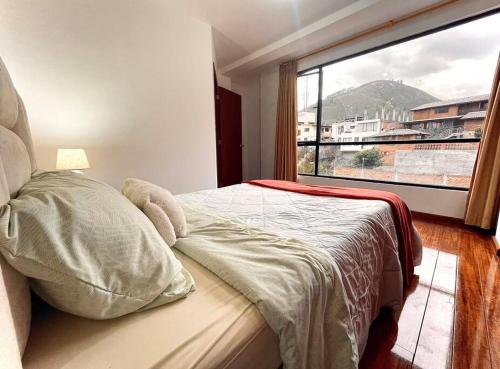 - une chambre avec un lit et une grande fenêtre dans l'établissement Casa de Madera y Mármol, à Ambato