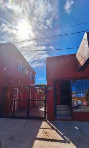 un edificio rojo con una puerta delante de una tienda en HOSPEDAJE DODERA en Gualeguaychú