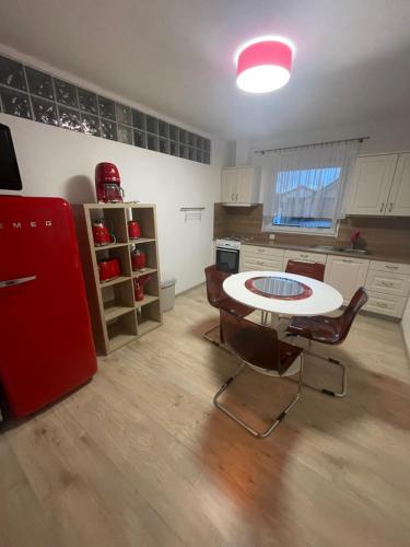 Il comprend une cuisine équipée d'une table, de chaises et d'un réfrigérateur rouge. dans l'établissement Apartmán U VINAŘSTVÍ v RD novostavba v Suchohrdly u Znojma, à Suchohrdly