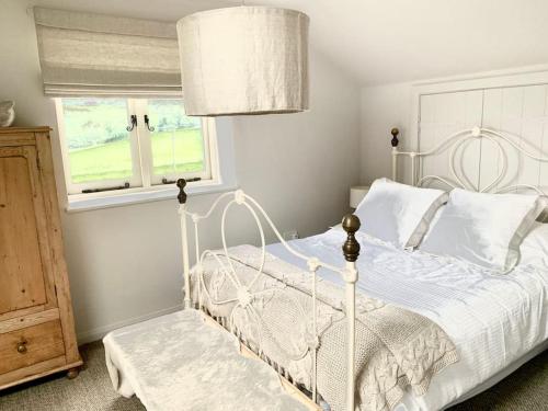 a bedroom with a white bed and a window at Guest Homes - The Teme Loft in Stockton on Teme