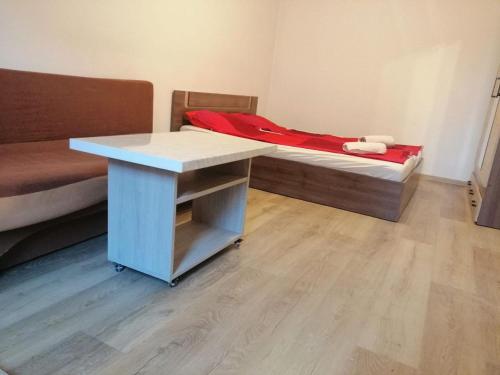 Habitación con cama, mesa y escritorio. en Affordable apartment close to the castle, en Hunedoara