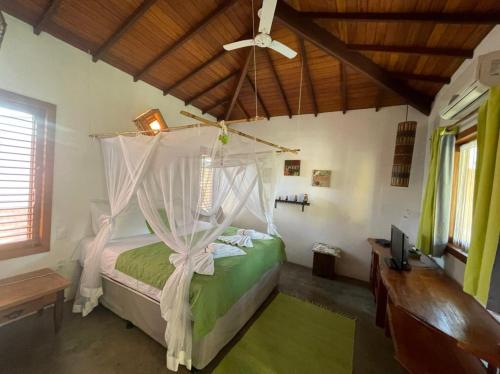 a bedroom with a bed with a ceiling fan at Guest House Villa 2 Santos in Arraial d'Ajuda