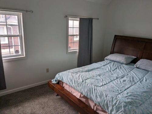 ein Schlafzimmer mit einem Bett und zwei Fenstern in der Unterkunft The Eclipse Erie in Erie