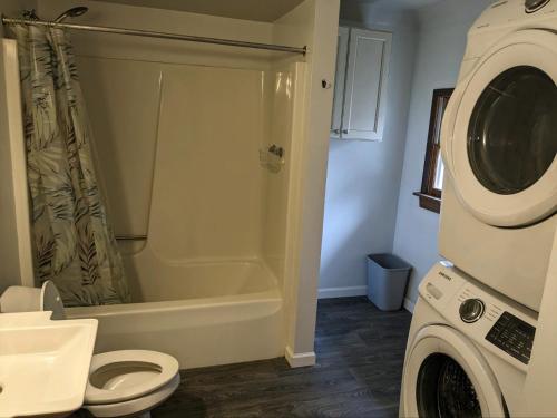 ein Badezimmer mit einer Dusche, einem WC und einer Waschmaschine in der Unterkunft The Eclipse Erie in Erie