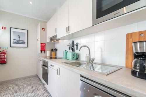 a kitchen with a sink and a microwave at Casa da Avenida 2 - Centro - Terraço Privado in Tavira