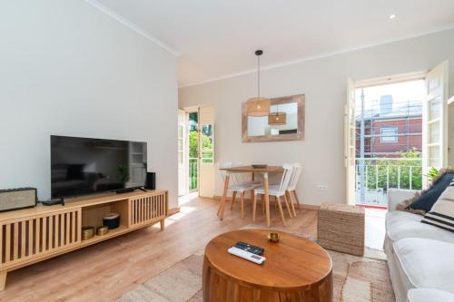 a living room with a couch and a tv and a table at Casa da Avenida 2 - Centro - Terraço Privado in Tavira