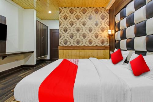 a bedroom with a large bed with red pillows at Hotel O THE HOTEL Oshin Hotel & Restaurant in Srinagar