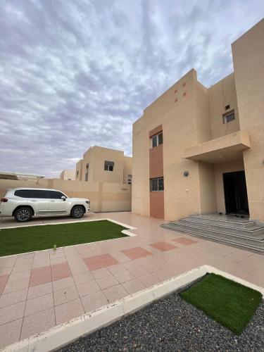 ein weißes Auto, das vor einem Gebäude parkt in der Unterkunft فيلا السلطان villa alsoltan in Al-'Ula
