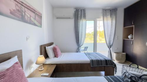 a bedroom with two beds and a window at Ismini Luxury Villa in vlicha