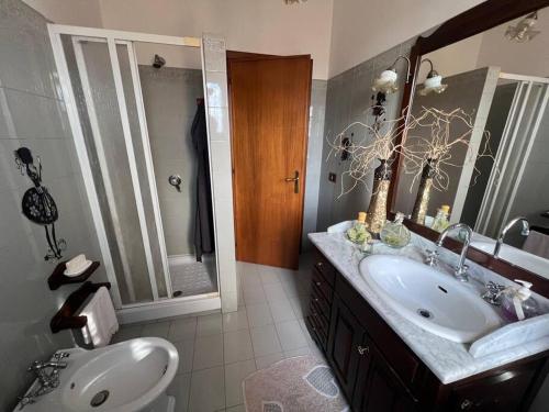 ein Badezimmer mit einem Waschbecken, einem WC und einem Spiegel in der Unterkunft Villa Pampaloni - Villa vacanze con Buffet di benvenuto in Fabrica di Roma