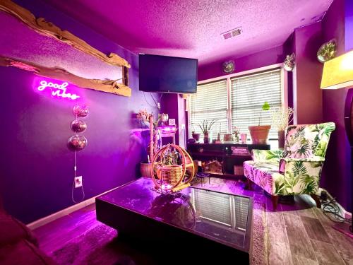 ein lila Wohnzimmer mit einem Sofa und einem Tisch in der Unterkunft African Zen Oasis in Atlanta