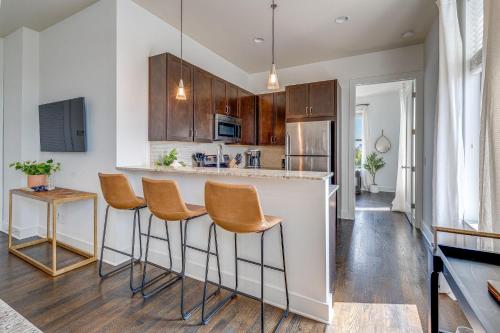a kitchen with a bar with chairs and a counter at LOFTS AT 30TH - MODERN LOFT - MINS TO BROADWAY in Nashville