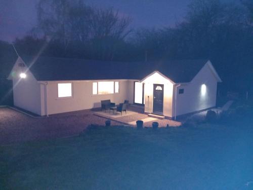 a house lit up at night with lights at The Bungalow, Forest of Dean in Coleford