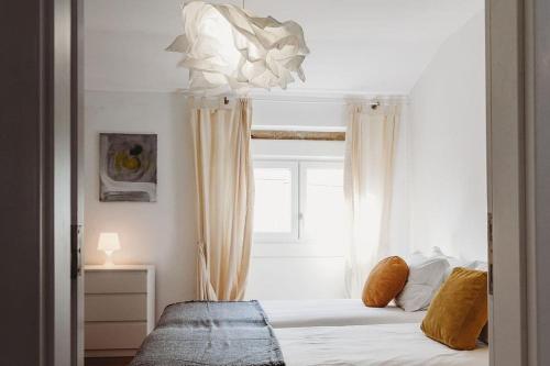 1 dormitorio con 1 cama blanca y ventana en Artist’s corner in central Caldas, en Caldas da Rainha