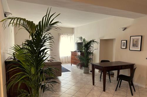 een woonkamer met een tafel en potplanten bij Holiday Home Curt de l'Elba with private garden and parking - Cernobbio in Cernobbio