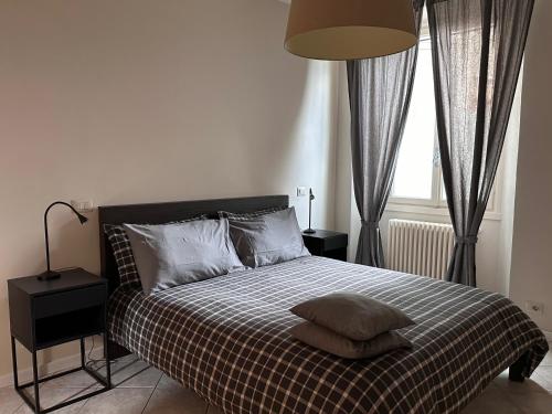 een slaapkamer met een bed met een geruite deken bij Holiday Home Curt de l'Elba with private garden and parking - Cernobbio in Cernobbio