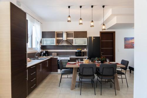 a kitchen and dining room with a table and chairs at Ismini Luxury Villa in vlicha