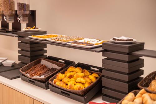a buffet line with many different types of food at Moov Hotel Porto Norte in Porto