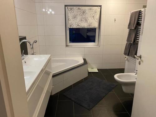 a white bathroom with a sink and a toilet at Ferienhaus Thomsen in Epenwöhrden
