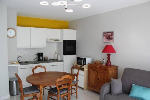 un salon avec une table et une cuisine dans l'établissement Appartement en rez-de-chaussée à Berck-Plage, à Berck-sur-Mer