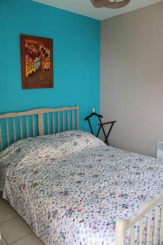 une chambre avec un lit avec un mur bleu dans l'établissement Appartement en rez-de-chaussée à Berck-Plage, à Berck-sur-Mer