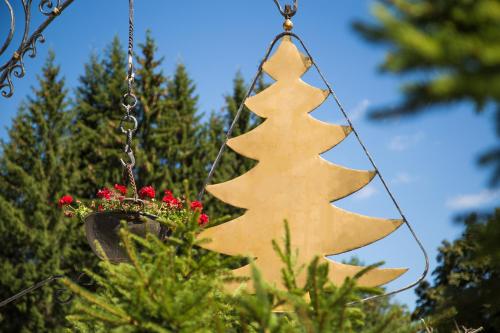 a wooden christmas tree hanging from a chain at Kaisers Tanne - Premium Alles Inklusive Hotel in Breitnau