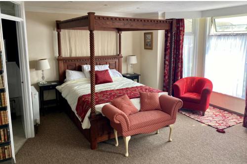 a bedroom with a canopy bed and a chair at Hotel Of Wizardry in Great Yarmouth