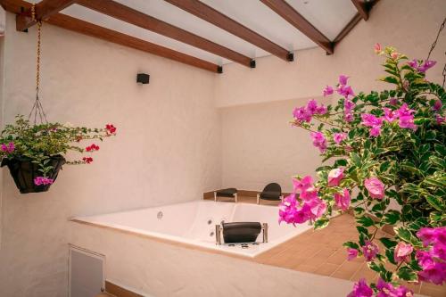 bañera en una habitación con flores rosas en Casa de descanso cerca al cañon del Güejar, en Granada