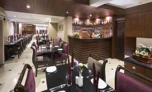 ein Restaurant mit Tischen und Stühlen und eine Bar in der Unterkunft Hotel Casa Fortuna in Kalkutta