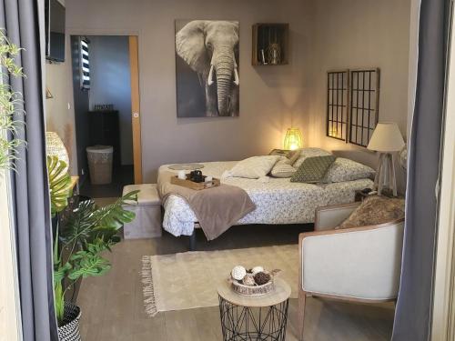 ein Schlafzimmer mit einem Bett und einem Elefantengemälde an der Wand in der Unterkunft La Grange Sud in Turnac