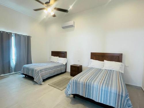 1 dormitorio con 2 camas y ventilador de techo en Casa Villa Sol Arena, en Cuatrociénegas de Carranza