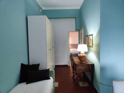 ein blaues Zimmer mit einem Bett und einem Tisch mit einer Lampe in der Unterkunft Jasmine in Letojanni