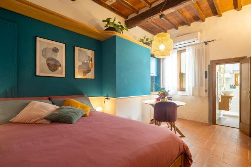 a bedroom with a bed and a blue wall at Ardiglione Flat in Florence