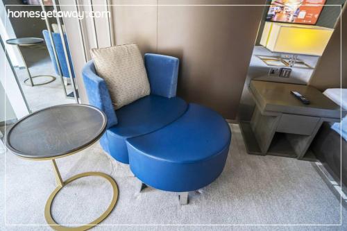 a blue chair and a table and a desk at Cozy 1BR Hyatt Creek Heights Residences in Dubai