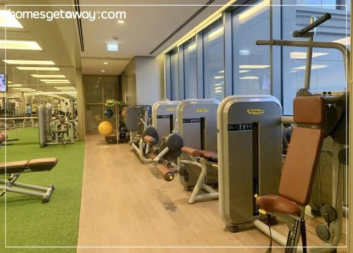 a gym with several rows of tread machines in a room at Cozy 1BR Hyatt Creek Heights Residences in Dubai